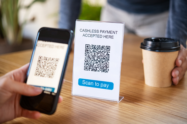 a person scanning a QR Code for cashless payment