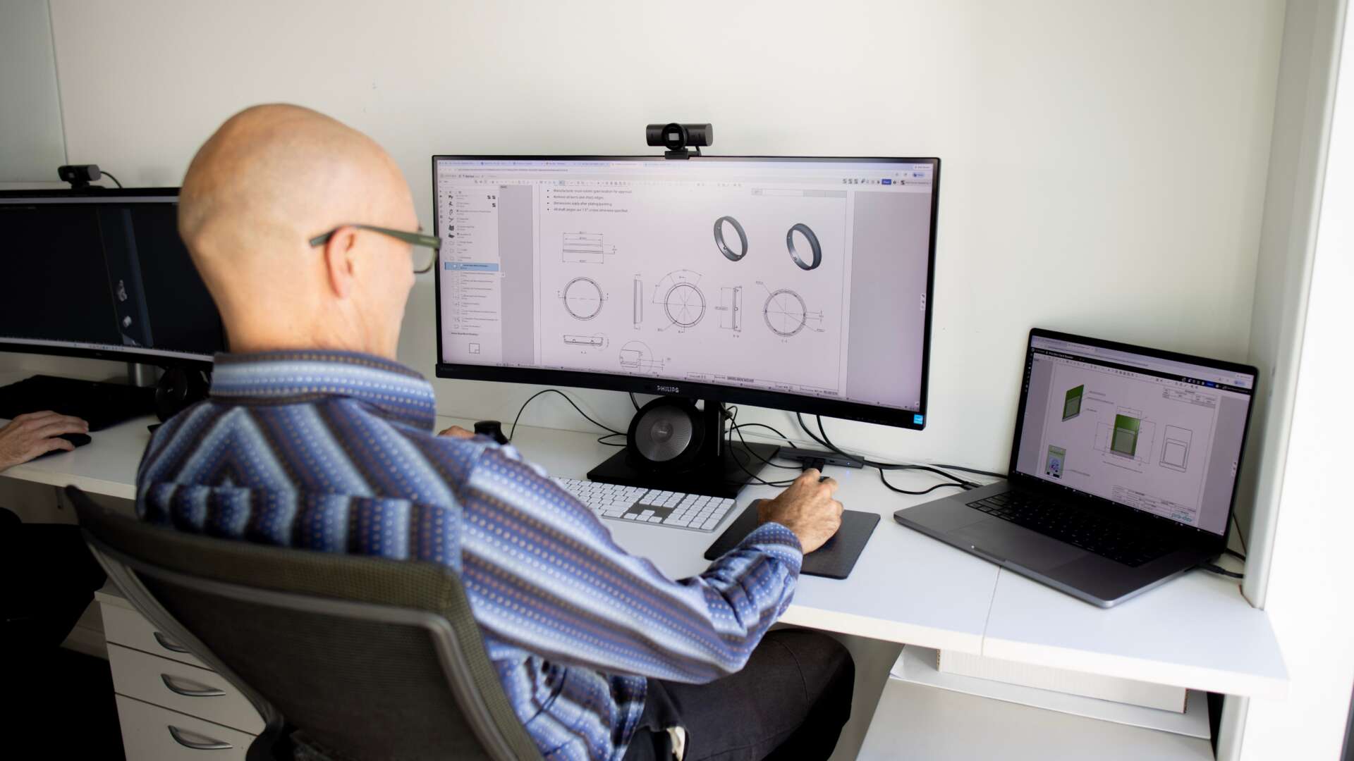 Pro-Dev engineer reviewing mechanical engineering drawings — physical product development